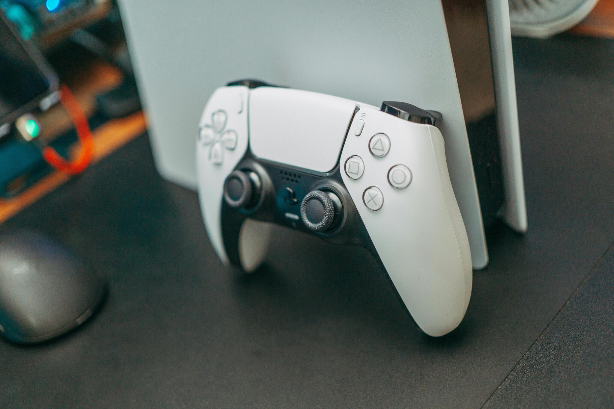 Konsola PlayStation 5 z leżącym na niej kontrolerem DualSense